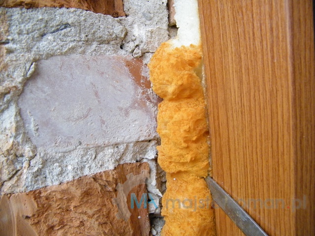 Wycinanie wystającej pianki między murem a ościeżnicą okna