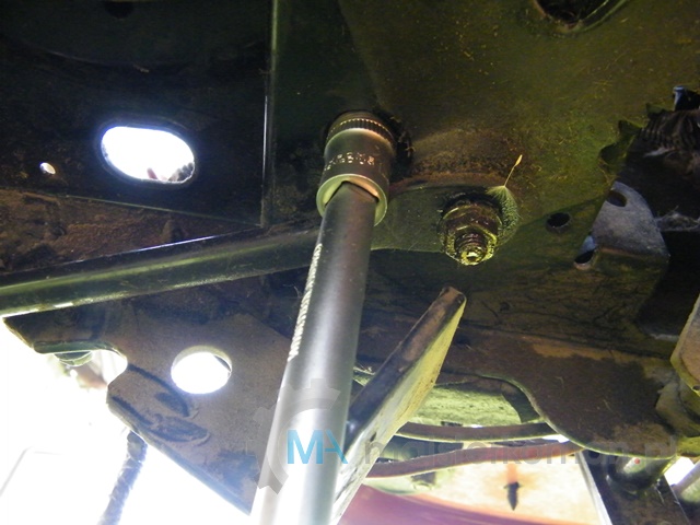 Odkręcanie śruby mocującej napęd obok układu kierowniczego